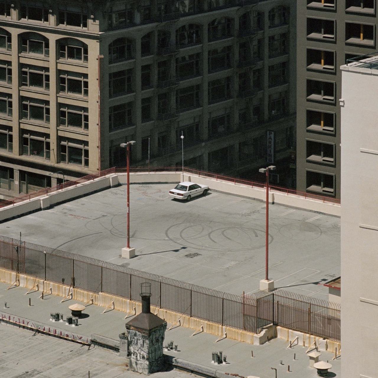 A white car parked on top of a high-rise building